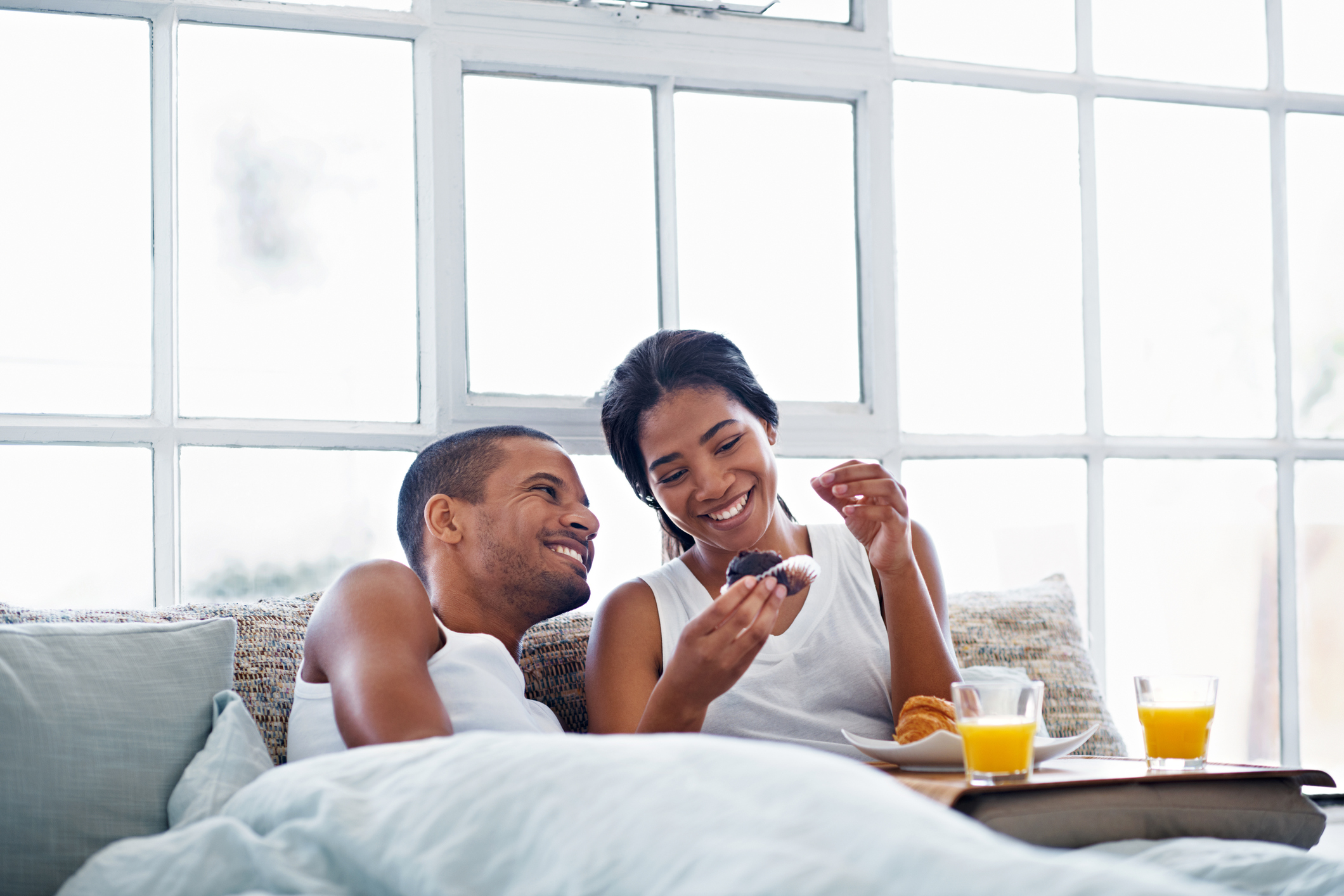 Shot of a smiling young couple enjoying breakfast in bed together